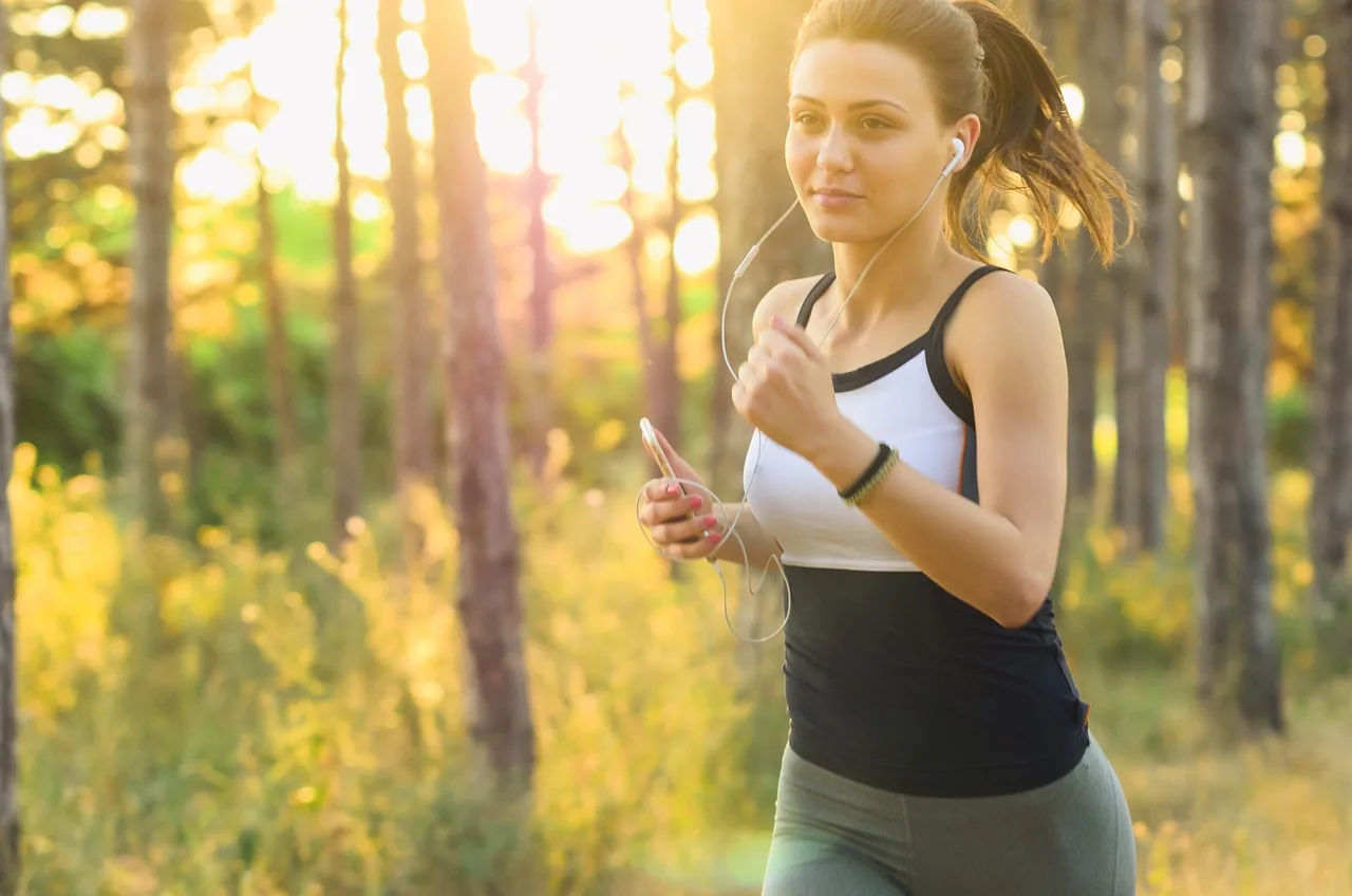 Woman jogging outdoors with water bottle and athletic wear