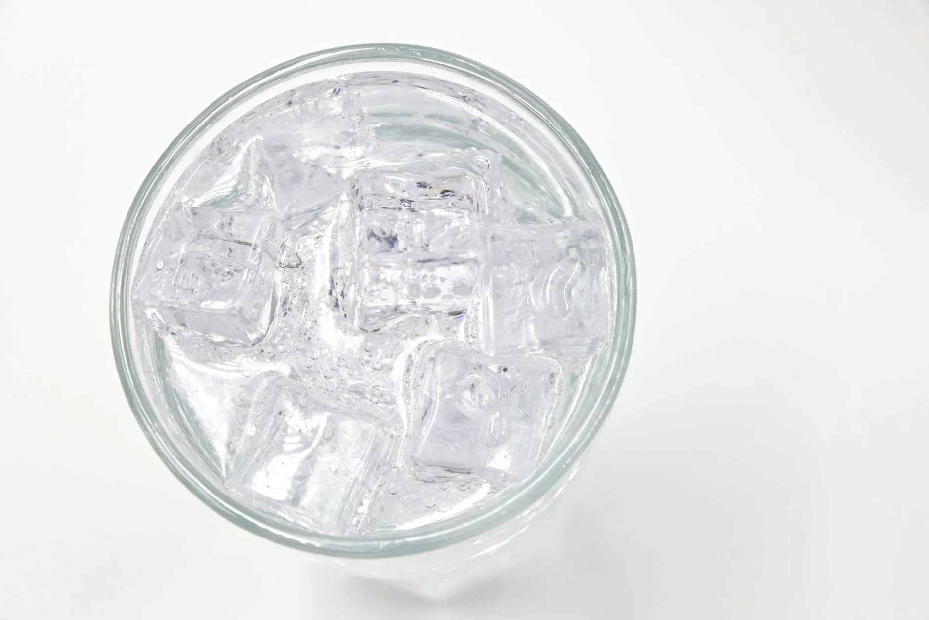 person drinking a glass of ice water in the morning
