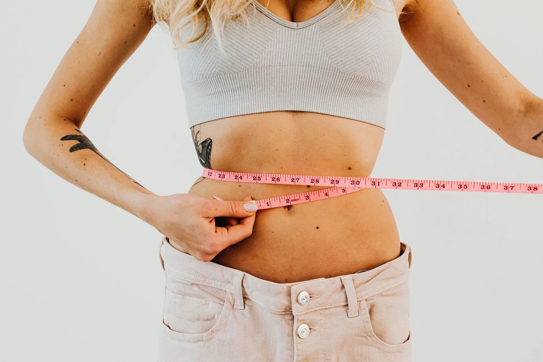 person measuring waist with tape measure