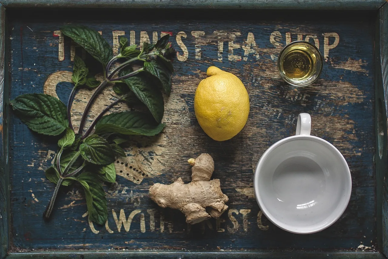 green tea and lemon on wooden table with measuring tape