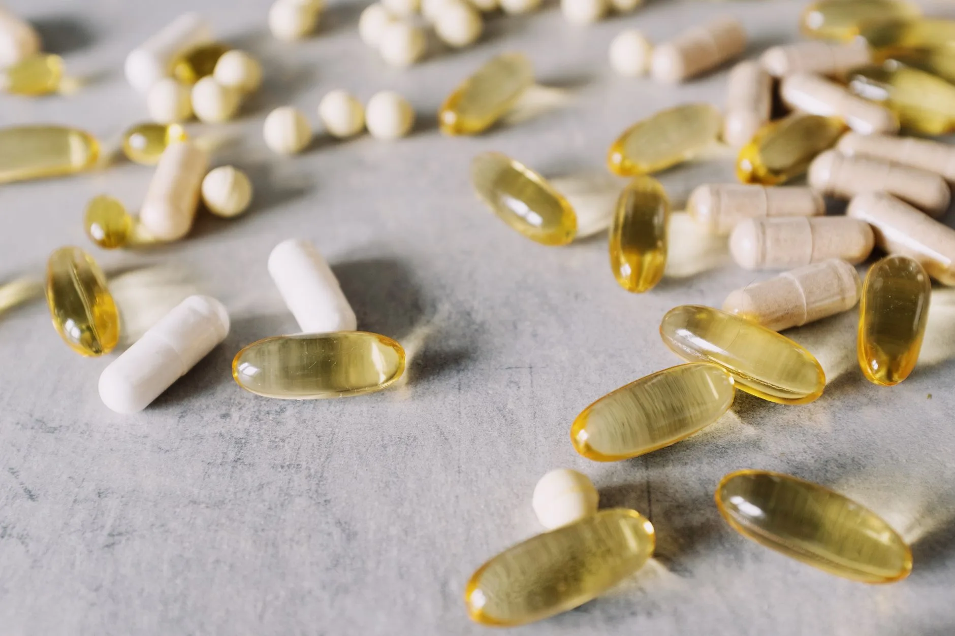 natural supplement capsules next to prescription pill bottle