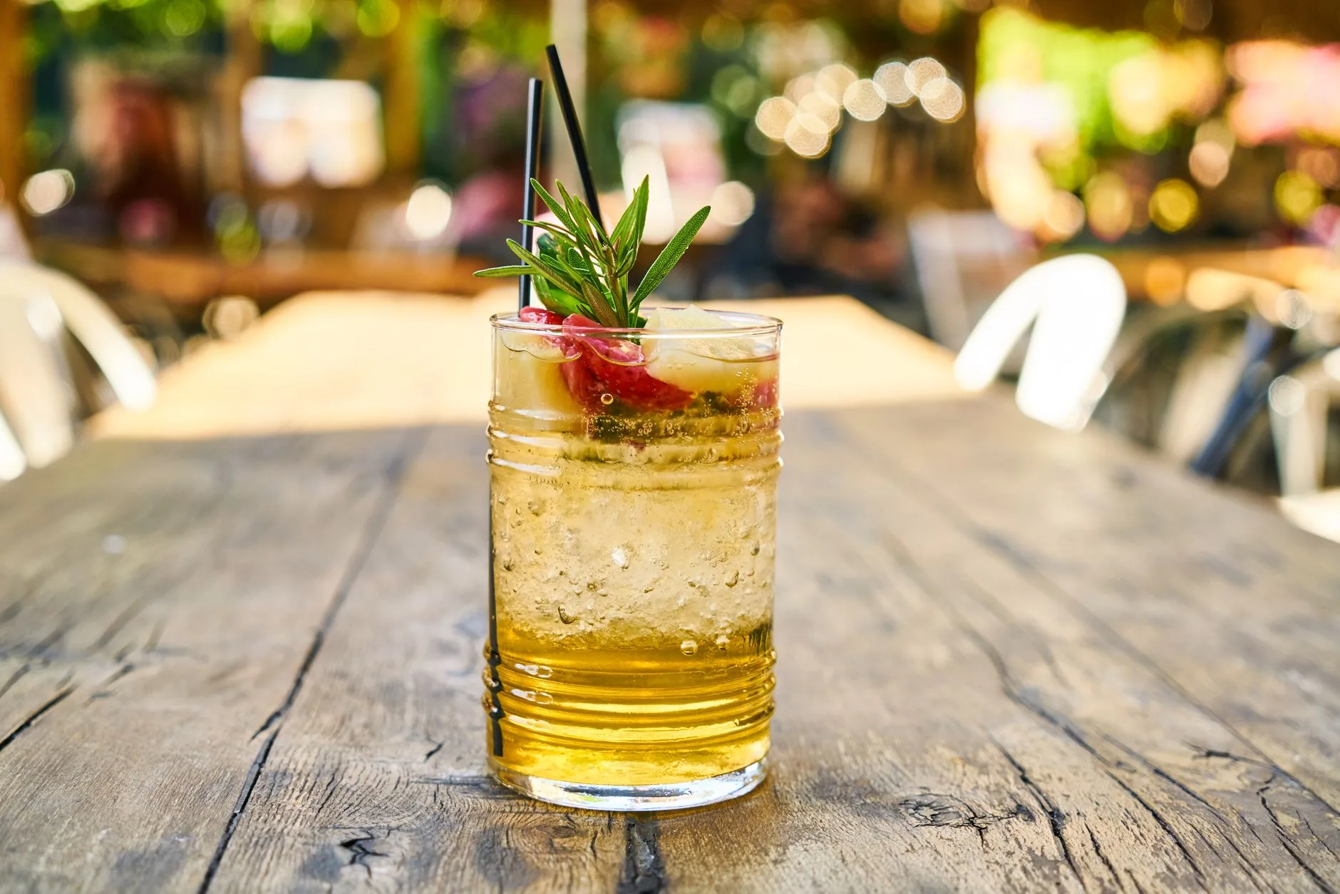glass of ice water with lemon on wooden table