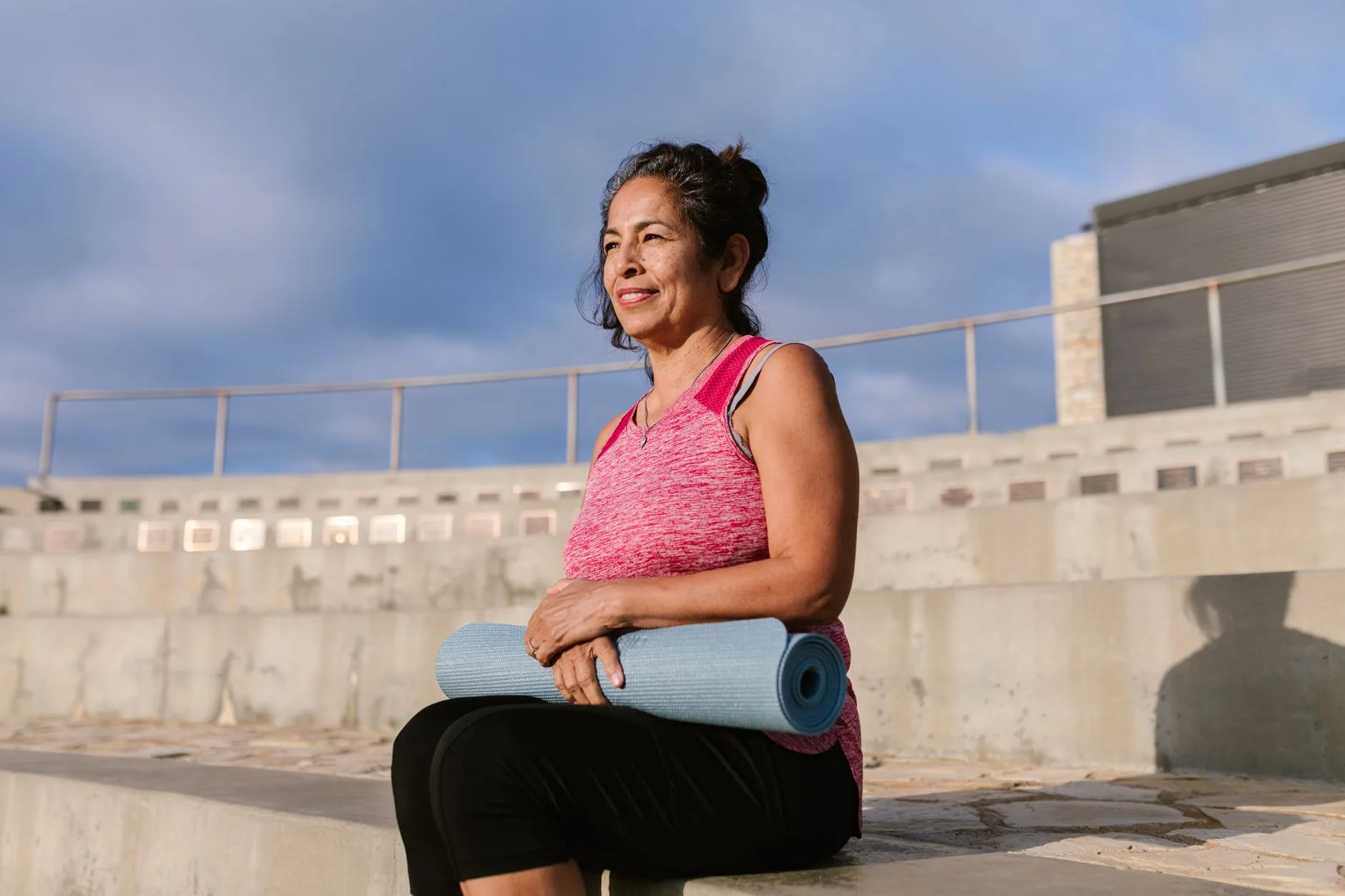 middle aged woman exercising outdoors in park smiling