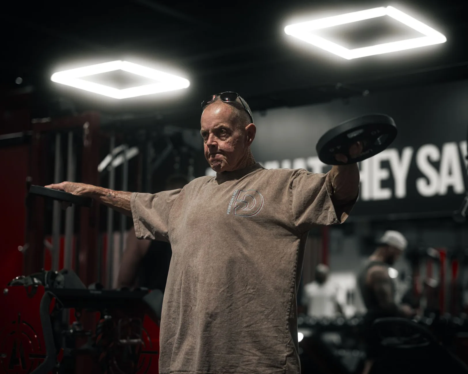 middle aged man lifting weights in gym resistance training