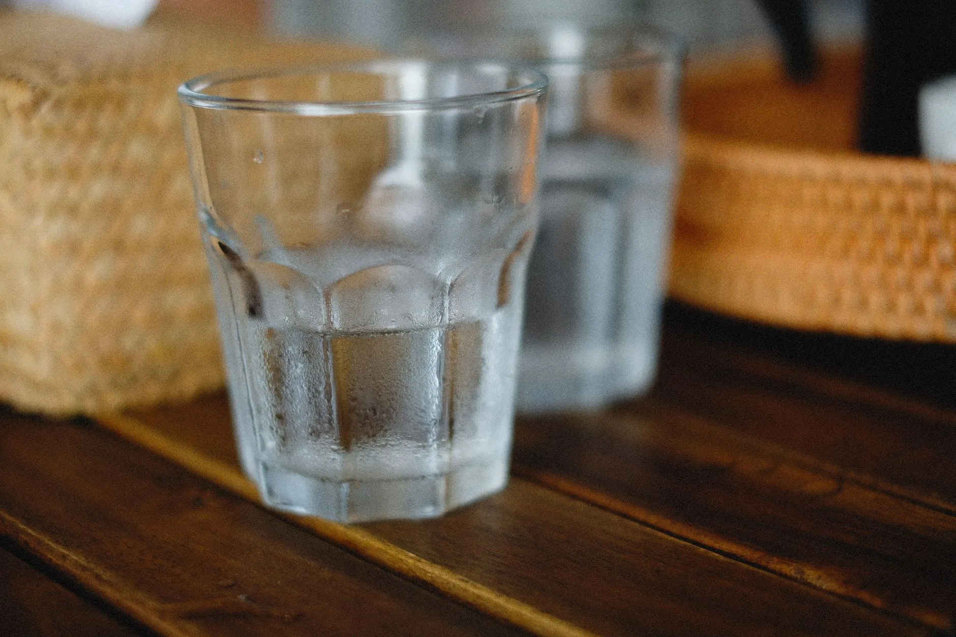 glass of ice water with condensation on wooden table