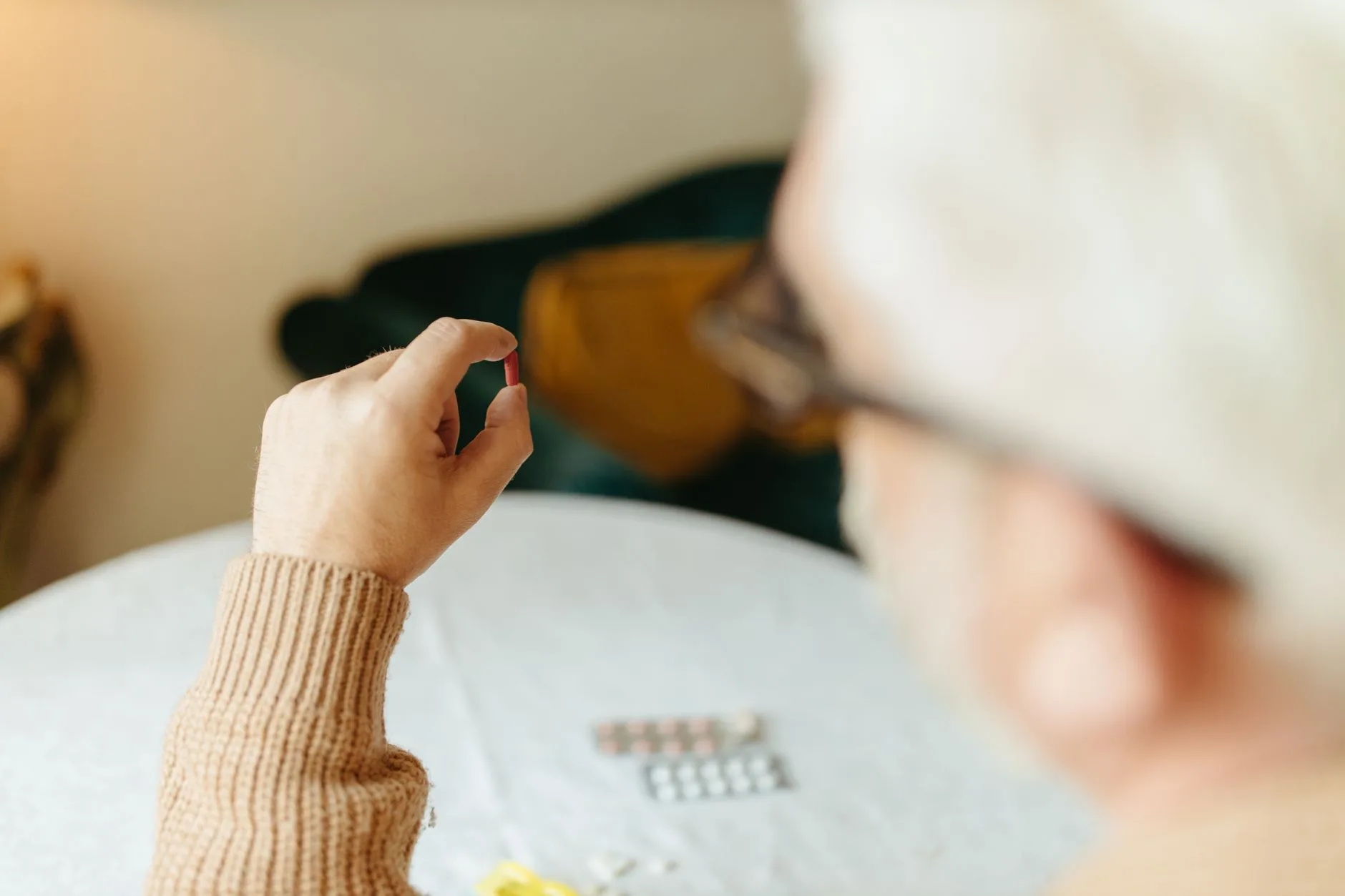 senior adult taking supplement capsule with water