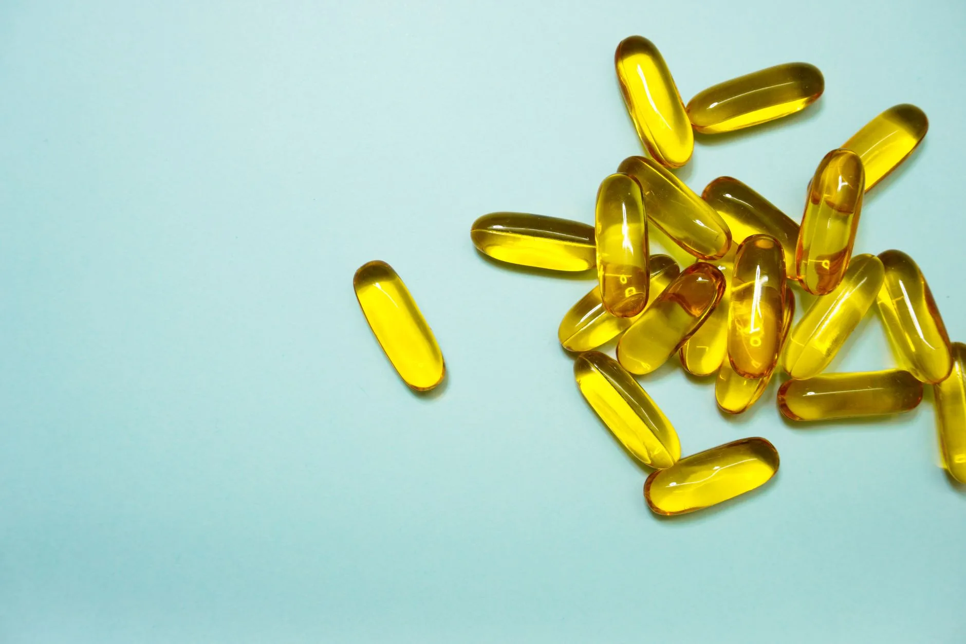 omega-3 fish oil capsules leafy greens vitamin bottles flat lay