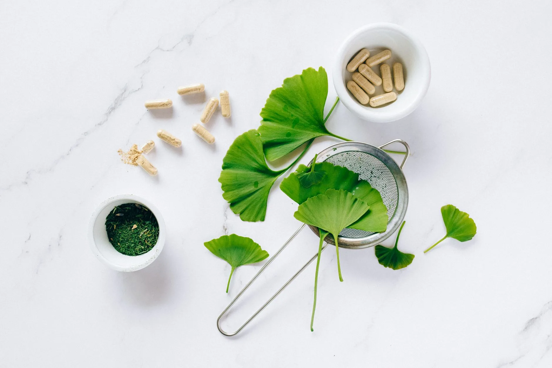 assorted brain health herbs and supplement capsules flat lay
