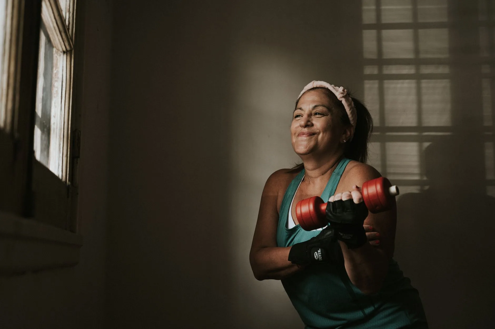 woman over 50 lifting light dumbbells