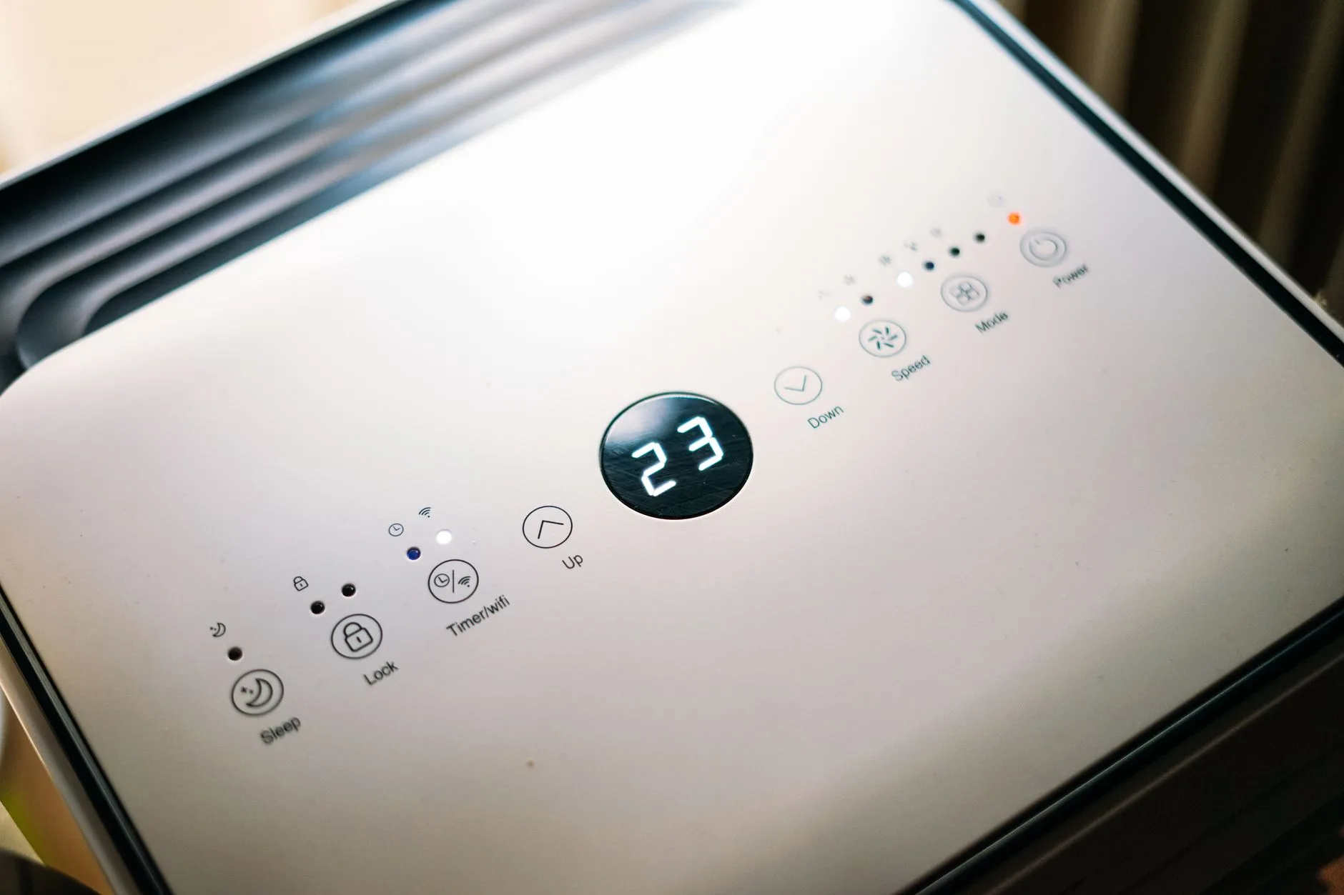 person adjusting portable cooling fan control panel