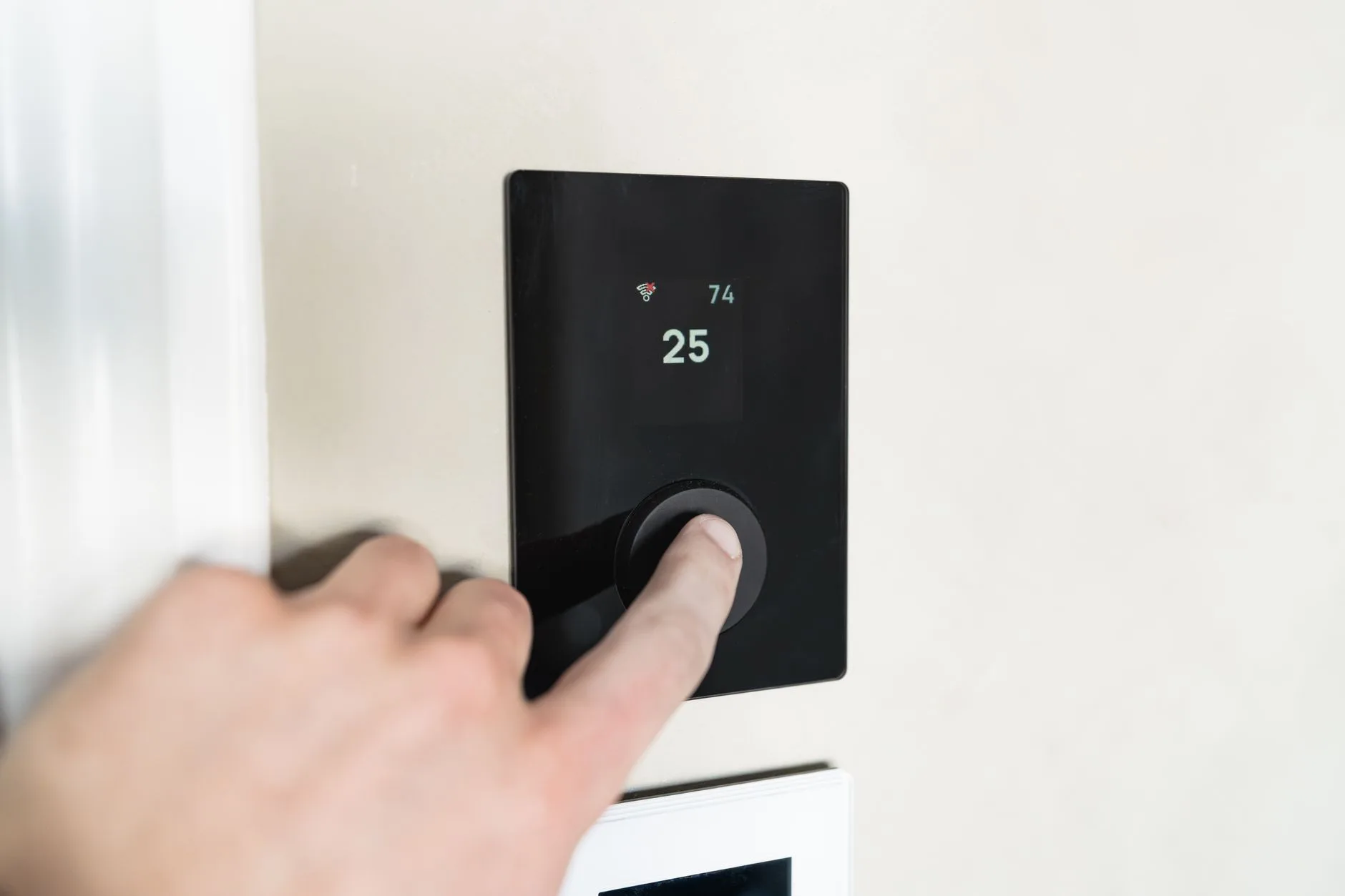 person adjusting portable fan controls at home office