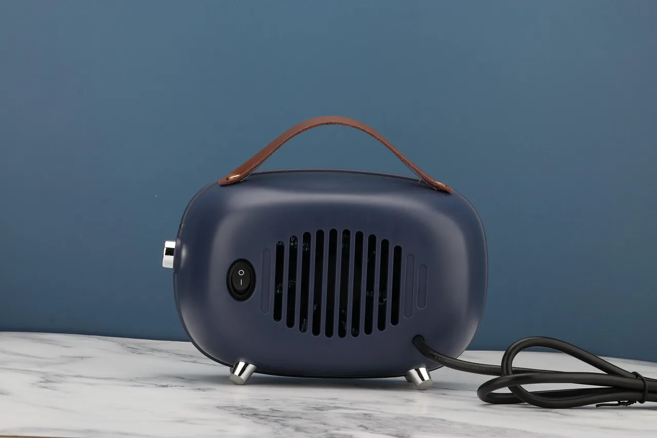 person adjusting temperature control on portable fan heater