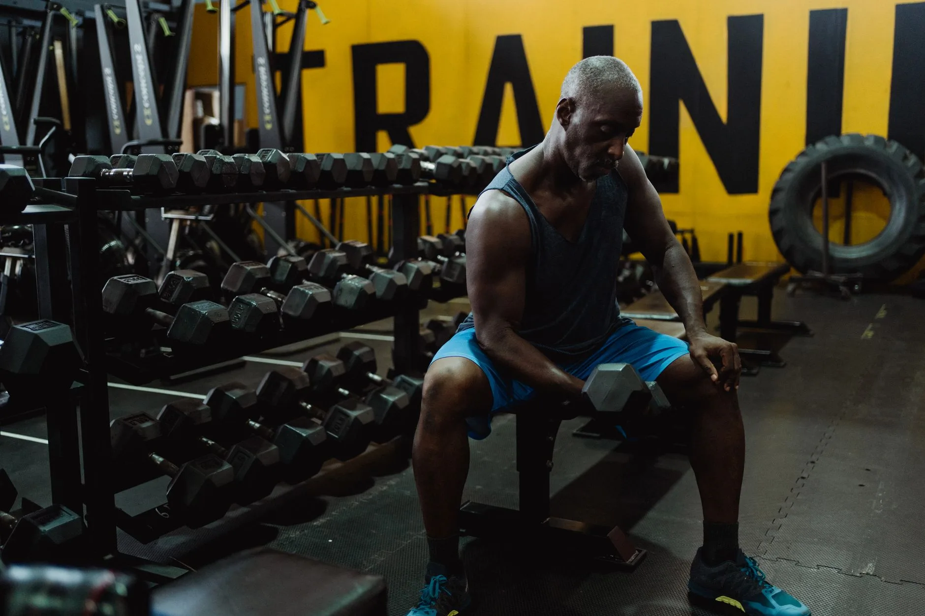 weight loss after 50 for men — middle-aged man lifting weights in gym