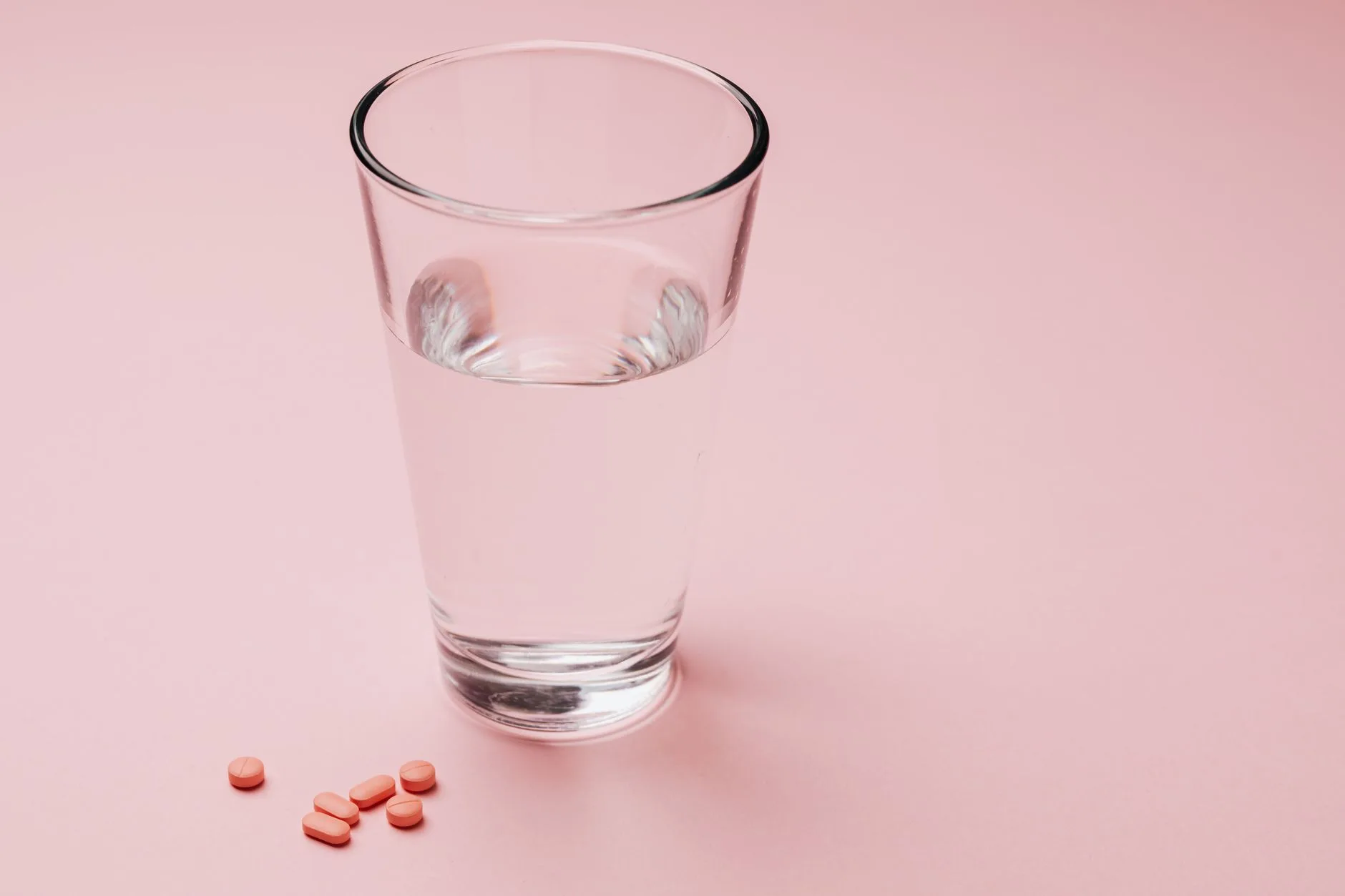 glucomannan fiber capsules with glass of water on table